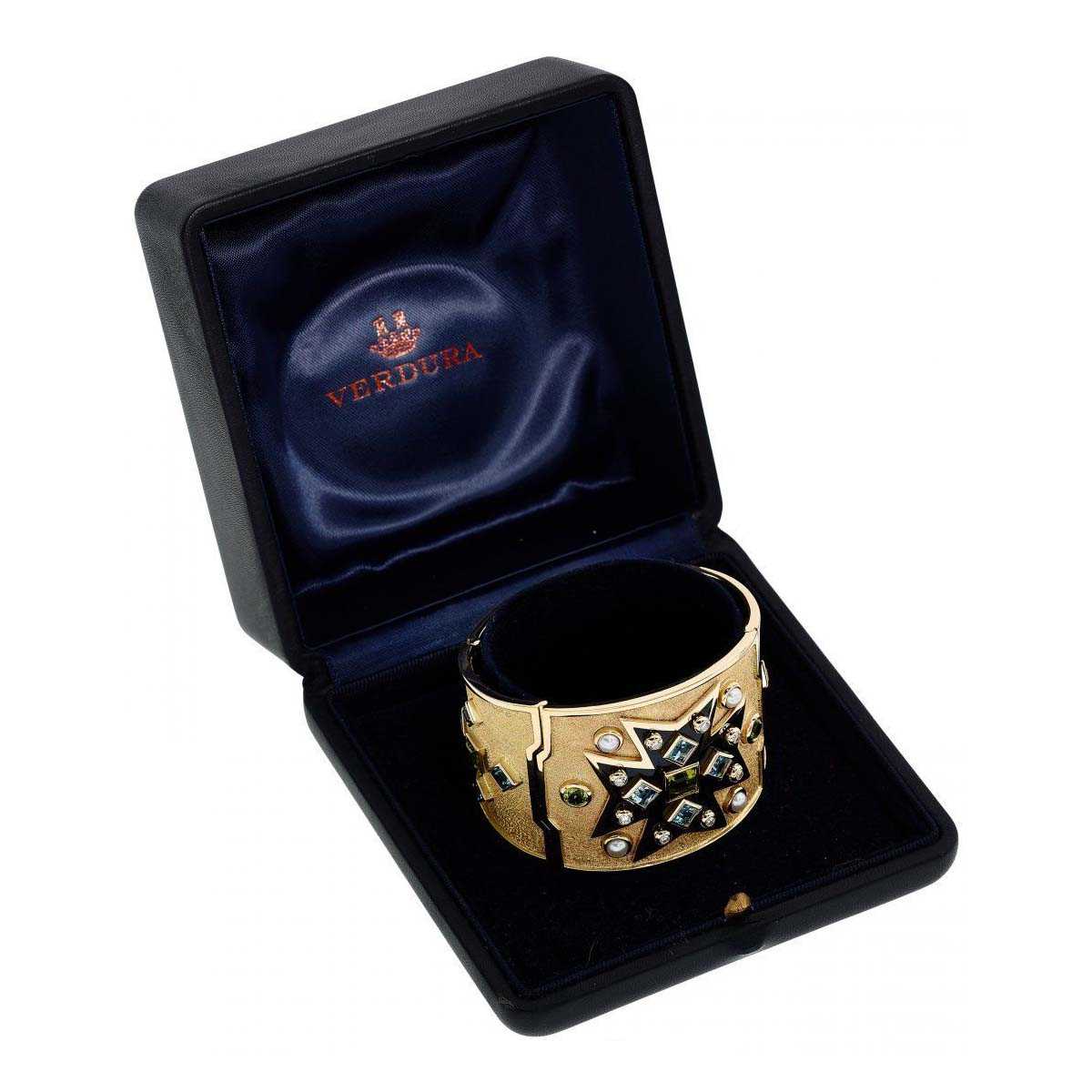 A Verdura Maltese Cross cuff in gold, black enamel, cultured pearls, blue topaz, peridot, and full-cut diamonds, shown in its box. It achieved $22,000 plus the buyer’s premium in December 2018. Image courtesy of Heritage Auctions and LiveAuctioneers.